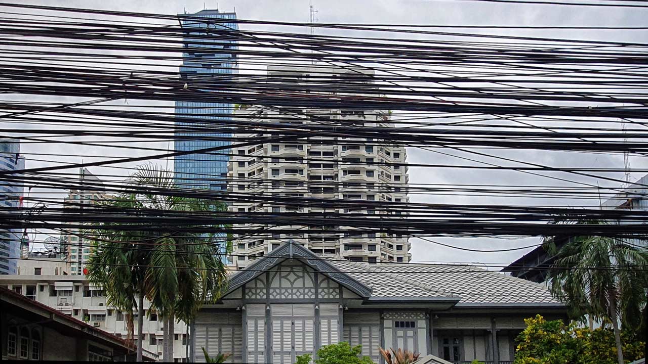 Una casa in stile classico Thai e il Mahanakhon Tower sullo sfondo, con un'infinità di cavi vista durante la mia passeggiata per Bangkok
